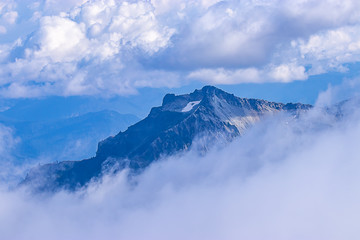 beautiful high mountain peak with cloud layers