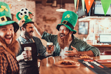 Excited friends and barman celebrating football championship and Saint Patrick Day