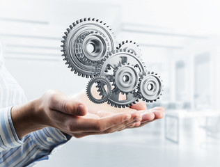 Engine mechanism in male ahnds as symbol for cooperation or team