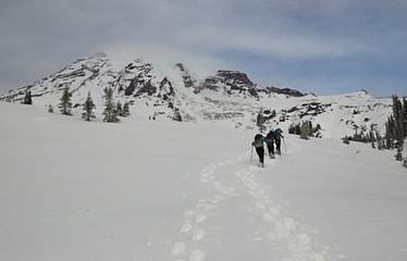 people snow shoeing and skiing on mt rainier in washington state