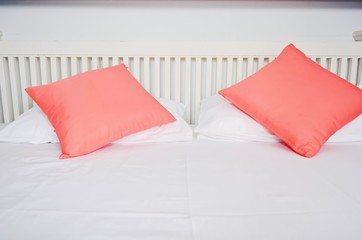 White and pink pillows on white mattresses