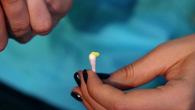 Ointment on a napkin, girl squeezes eye ointment on a napkin, Squeezing out an ointment from a tube, Treatment of the eyelid with ointment on the cotton swab to fight the mite demodex,  