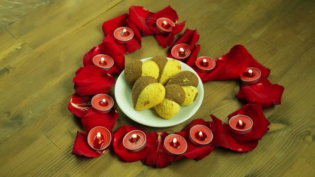The girl puts a plate of cookies in the middle of the heart