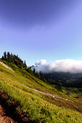 Fototapeta na wymiar dark shadowy mountail landscape with fluffy white clouds