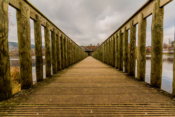 Obraz premium beautiful image of a way on a wooden bridge leading to a gazebo in the middle of the lake in Vielsalm on a wonderful autumn day in the Belgian Ardennes