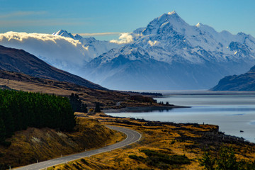 Aoraki/Mount Cook, road and turquoise lake Pukaki view from Peter´s Lookout, South Island, New Zealand. Warm colours, clear sky, snowy mountain tops. Iconic scenic New Zealand photo. Must visit place!