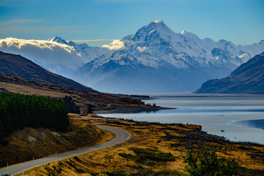 Aoraki/Mount Cook, road and turquoise lake Pukaki view from Peter´s Lookout, South Island, New Zealand. Warm colours, clear sky, snowy mountain tops. Iconic scenic New Zealand photo. Must visit place!