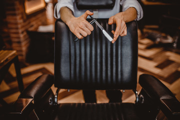 Close up workplace barber shop, chair stylish interior. Male hairdresser on background