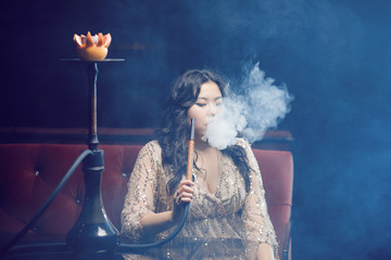 Beautiful young asian woman with hookah in lounge bar