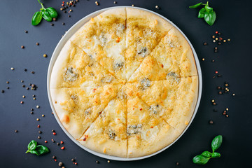 Italian pizza on a dark background, top view