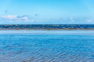 blue sky white clouds over calm body of water