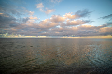 blue sky white clouds over calm body of water