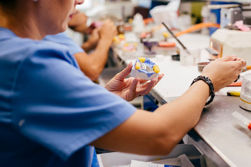 Caucasian woman working on a dental prosthesis