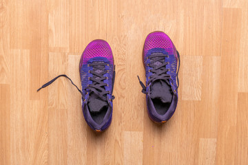 top view of couple of purple sport shoes sneakers on the wooden parquet in the gym f