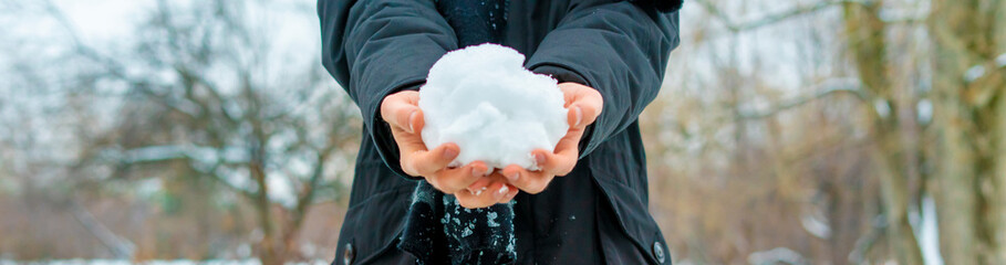close up hands holding snow on a winter day outdoors f