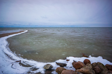 lakeside beach details with sand, rocks and blur background