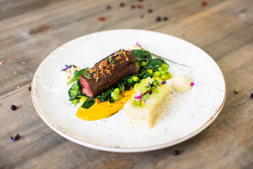 Beef meat with green peas, sweet potato mousse, roasted spinach and zucchini gratin