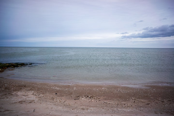 lakeside beach details with sand, rocks and blur background