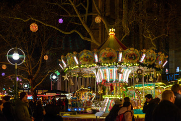 Night outdoor colorful  illuminated carousel and crowded on the street of Christmas market in...