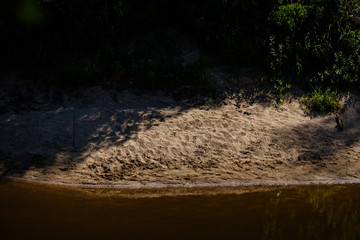 lakeside beach details with sand, rocks and blur background