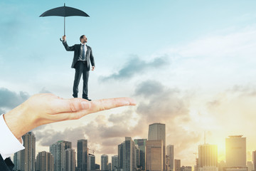 Hand holding man with umbrella