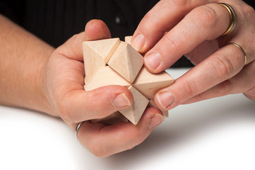 Fototapeta premium closeup of woman hand with wooden puzzle on white table background