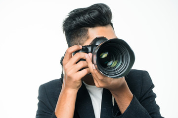 Young indian man with camera isolated over white background.