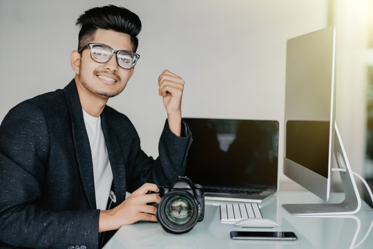 Cheerful Asian Reporter Working In Office On Laptop