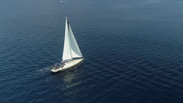 Aerial view of a sailboat driving in the mediterranean sea, Vathi, Greece.