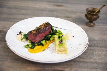 Beef meat with green peas, sweet potato mousse, roasted spinach and zucchini gratin