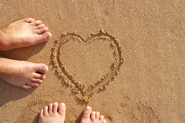 Beach couple in love with heart on sand background. summer, happy weekend concept.