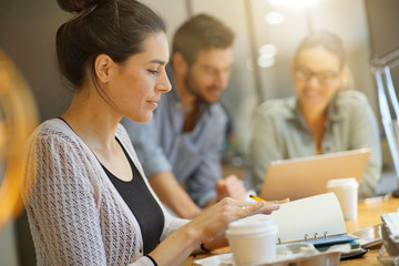 Obraz premium Focus on attractive brunette looking at camera in co working space