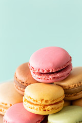 macaroons cake in soft colors on the pastel green glass background.