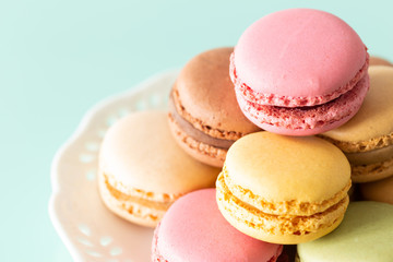 macaroons cake in soft colors on the pastel green glass background.