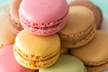 macaroons cake in soft colors on the pastel green glass background