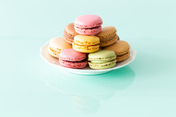 macaroons cake in soft colors on the pastel green glass background.
