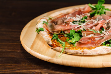 Pizza with ham and vegetables on wooden table