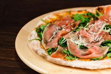 Fototapeta na wymiar Pizza with ham and vegetables on wooden table
