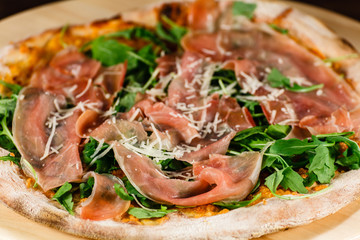 Pizza with ham and vegetables on wooden table