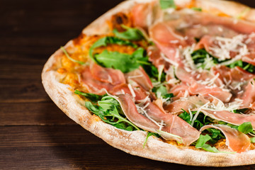 Pizza with ham and vegetables on wooden table