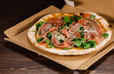 Pizza with ham and vegetables on wooden table