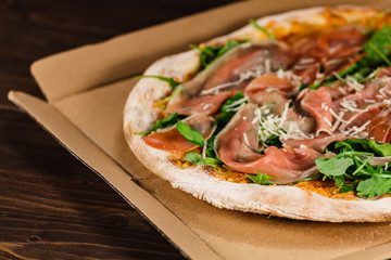 Pizza with ham and vegetables on wooden table