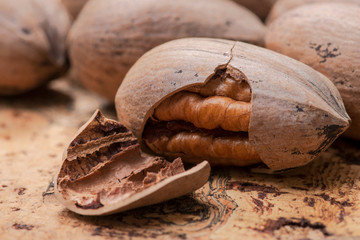 Fresh organic pecans nuts in wooden bowl on natural cork background.