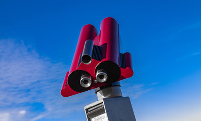 Rotes Fernrohr vor blauem Himmel