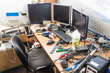 A messy desktop with stacks of files and other documents, all kind of office supplies and part of a...