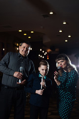 Family karaoke. Portrait of a happy family, singing in microphones