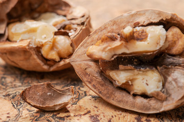 Brown premium raw organic walnuts on natural cork background.
