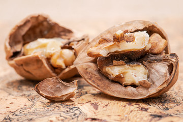 Brown premium raw organic walnuts on natural cork background.