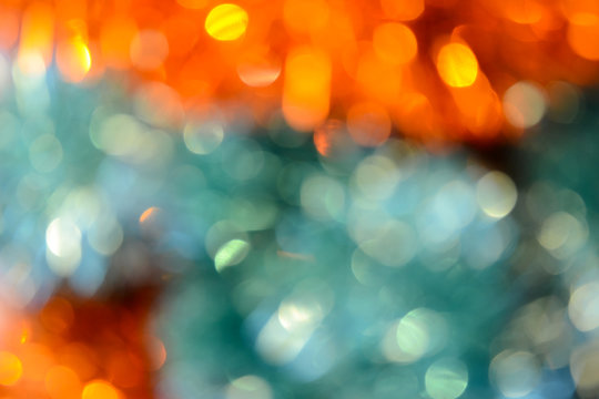 Bokeh. Holiday background. Christmas lights. Glitter. Defocused sparkles. New Year backdrop. Festive wallpaper. Blinks. Carnival. Bokeh retro style photo. Orange.