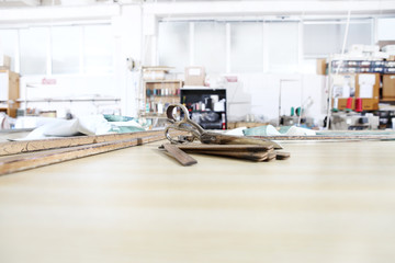tailor's tools, old scissors, wooden meter and ruler on the sartorial work table